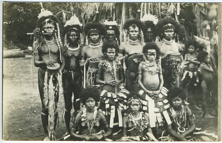 Item #14031 New Guinea men, women and children in ceremonial dress. Photographic postcard.